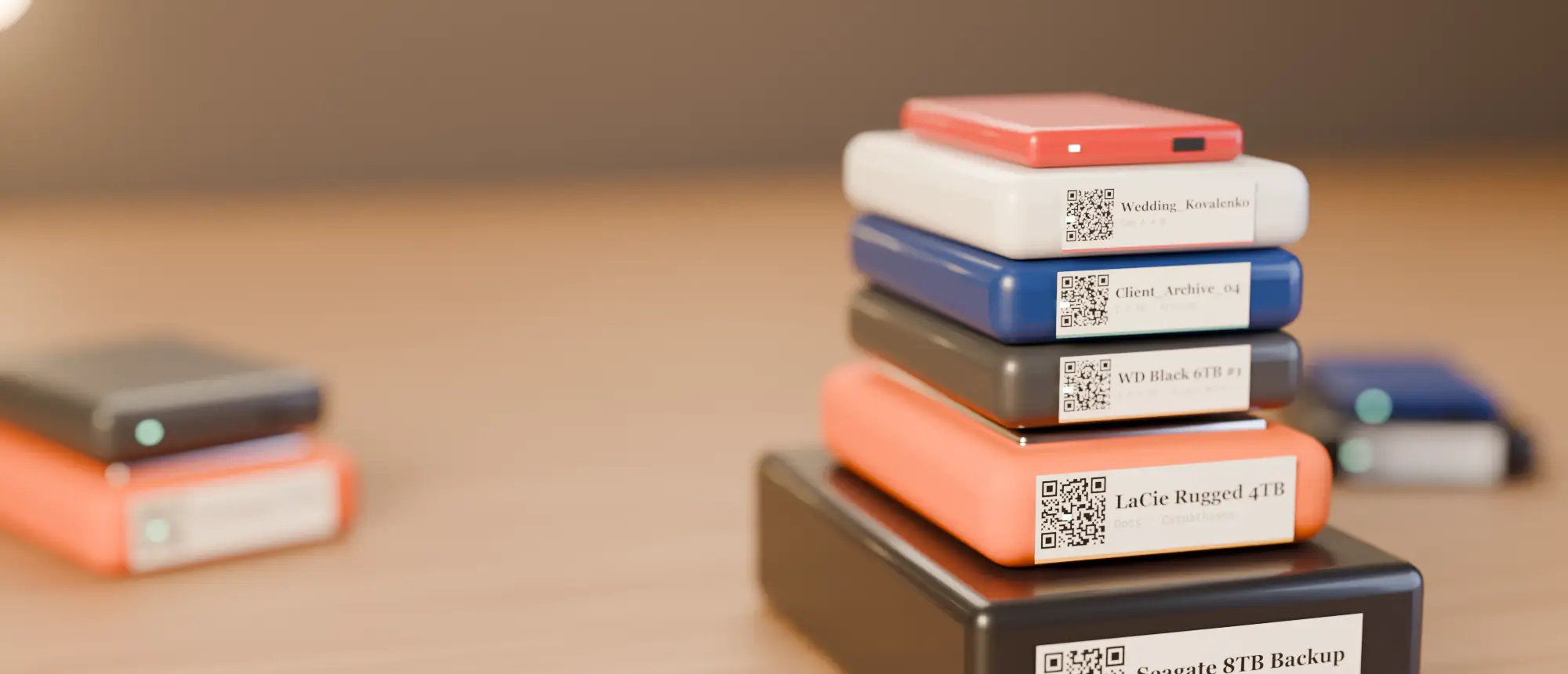 A neat stack of external drives, each with a QR label